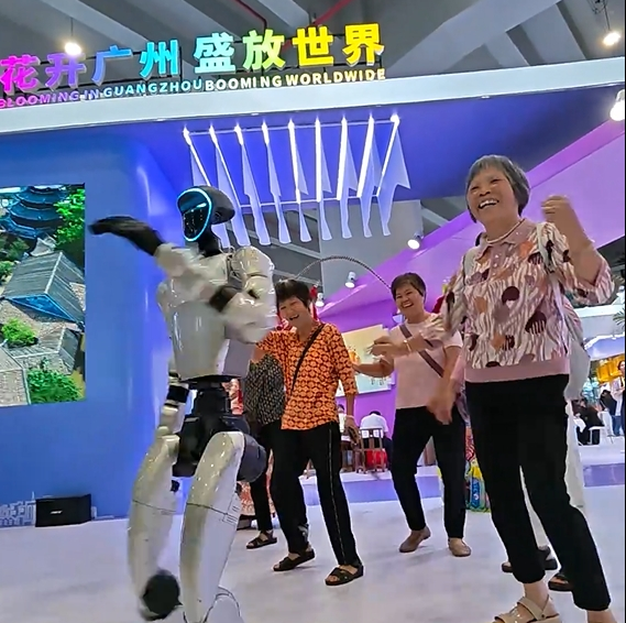 Visitors happily dance with robots at Guangzhou International Travel Fair